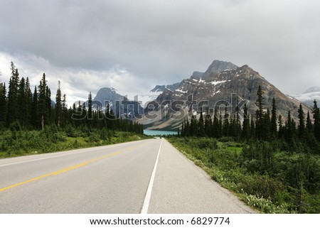 Photo of a road leading into the mountains.  Displays roadtrip and travel by automobile concepts.