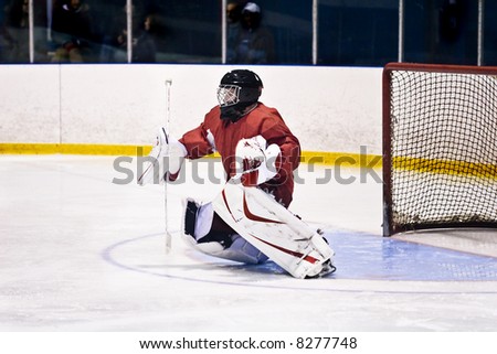 Hockey goalie in generic red equipment.  Photo has a grungy look to it.