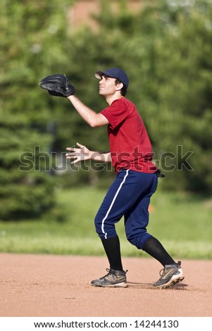 A baseball player is playing in the field.  The player is getting ready to catch a pop fly