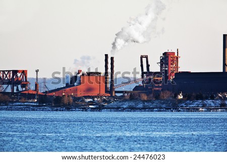 Smoke and steam polluting the environment at a manufacturing plant.