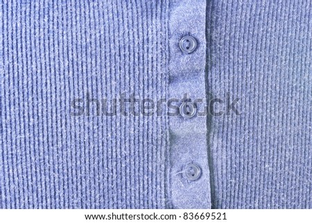 Row of buttons on a blue cotton knit shirt.