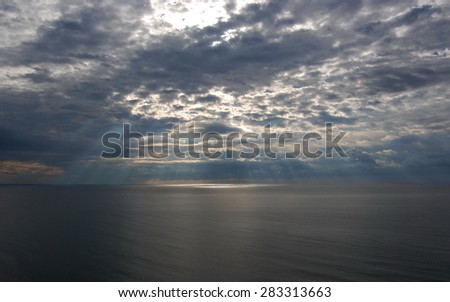 Sunshine make the way through clouds over a sea surface. Black Sea.