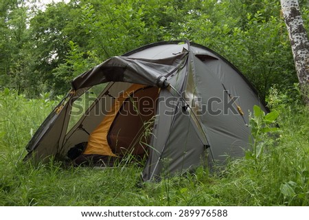 Tourist tent in spring forest.