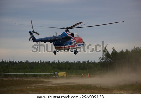 MURMANSK REGION, RUSSIA - AUGUST 26: Regular helicopter Mi-8 landing in cloud of dust on rural airfield on august 26, 2014 in the remote village of Krasnoshchelye of Murmansk region, Russia.