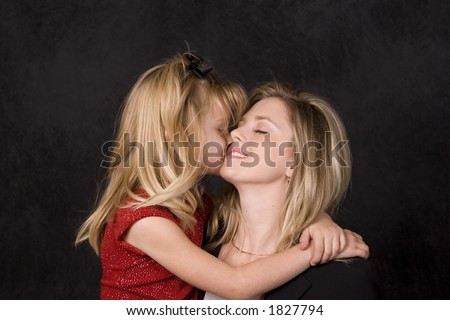 beautiful young daughter hugging and kissing mother