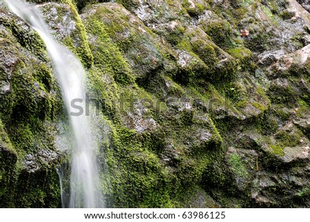 Water runs over moss covered rocks