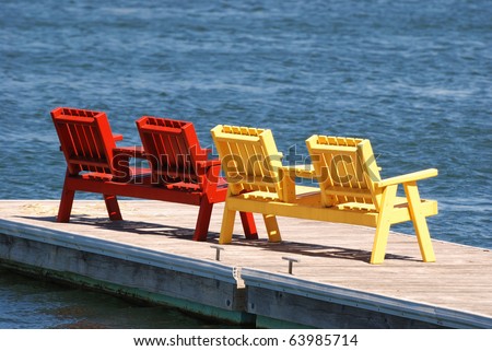 Brightly colored chairs sit on a dock.