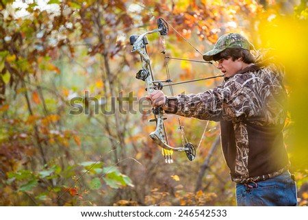 southern american teen boy out in the woods bow hunting for deer