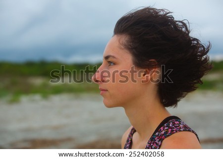 Young woman\'s head with hair being blown back by the wind. St Simons Island, Brunswick, Georgia