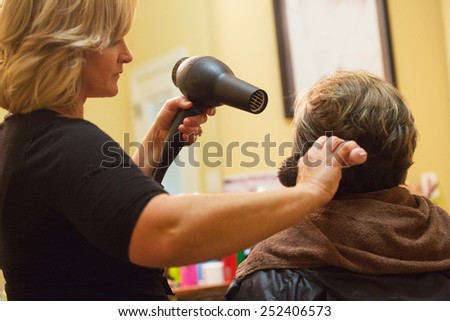 mature woman getting her hair cut at a home salon