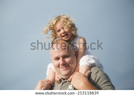 father with daughter riding on his shoulders