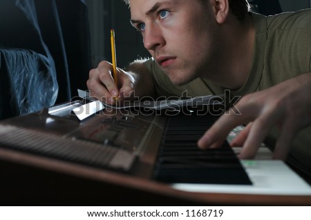 A scruffy young man writing music.