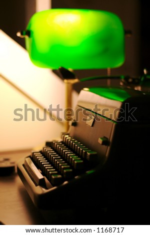 An old typewriter on a desk with a green lamp.