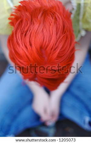 Woman with red hair, head bowed.