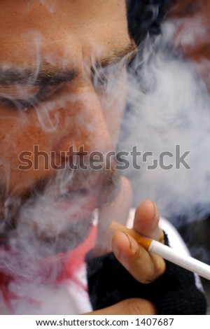 A man surrounded by a cloud of smoke from his cigarette.