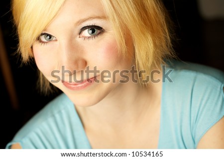 A head and shoulders shot of a beautiful young woman smiling and looking into the camera.