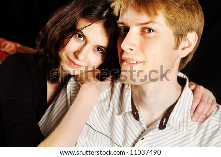 A portrait of a guy and a girl. Focus is on the guy in front.