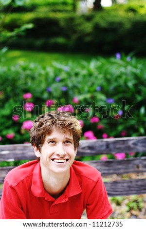 Young man sitting on a bench having a GREAT day.