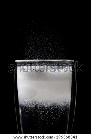 Bubbles in a freshly poured soft drink on a black background