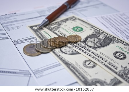 pay checks, pen, coins and US dollars