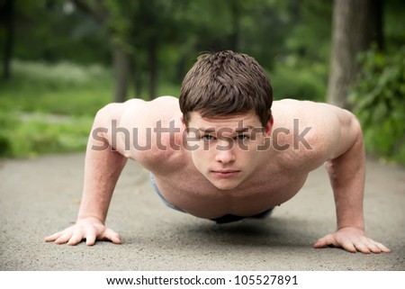 Push ups workout. Young man making pushups, outdoors