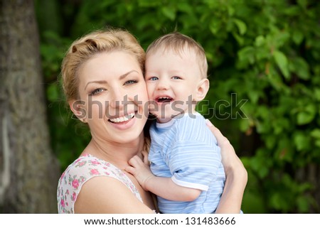 happy blond mom and one year old son enjoying nature together