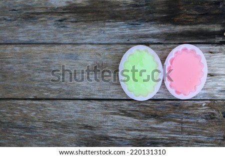 Coconut pink and green jelly on old wood background.