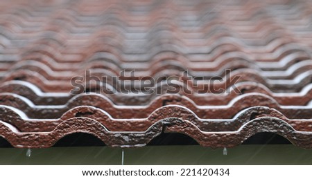 Falling Rain drop on brown brick roof, close up.