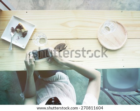 vintage, woman with smart phone and water glass and cake at the bar