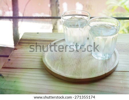 Vintage, glass of water on wood table bar background.