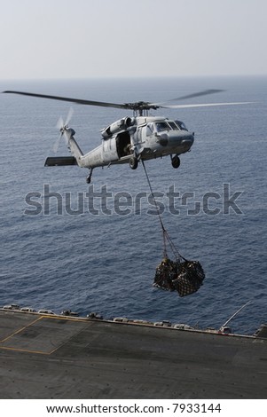 A Navy SH-60 Helicopter Performs Replenishment At Sea On a Nuclear Aircraft Carrier