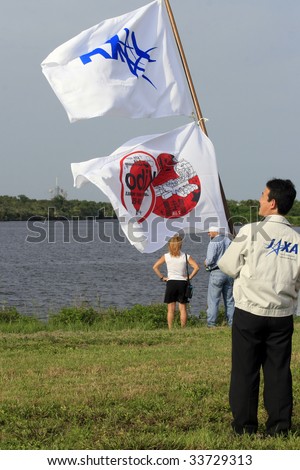 CAPE CANAVERAL, FL - JULY 15: A member of the Japanese Space Admin hoists a flag in honor of the Japanese Kibo module, launched by Space Shuttle Endeavour from Kennedy Space Center on July 15, 2009 in Cape Canaveral, FL.