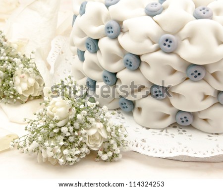 White wedding cake with blue flowers on white background