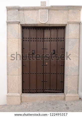 Old wooden door with handles, with the number forty-five in the top