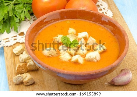 Cold gazpacho soup with tomato, bread, ham and vegetables