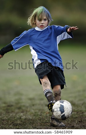 Boy plays soccer in a a blue shirt