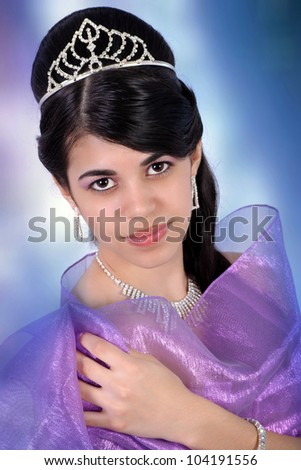 Pretty Latin girl wearing a purple dress and a crown