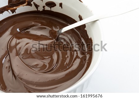 Close up of melted chocolate in a white pot. Delicious and popular sweet staple. Texture and highlights in one of the most popular sweet food.