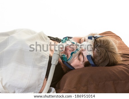 Hispanic middle age woman suffering from sleep apnea. Wearing a mask to relieve the condition