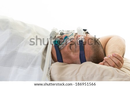 Hispanic middle age  and obese man suffering from sleep apnea and wearing cpap mask to relieve his condition or sleeping disorder