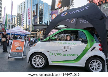 TORONTO,CANADA-MAY 24, 2014: Smart cars marketing its electric cars to children in Dundas Square. Smart Automobile is a division of Daimler AG that designs, manufactures and markets microcars.