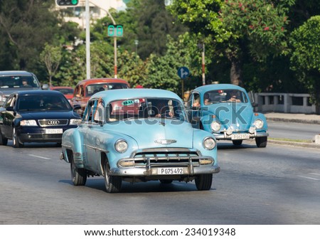 HAVANA,CUBA-JULY 3,2014: Old American cars running and making income for owners. The car supply limitations has made Cubans innovate to keep cars from the 50's running and make income with them.