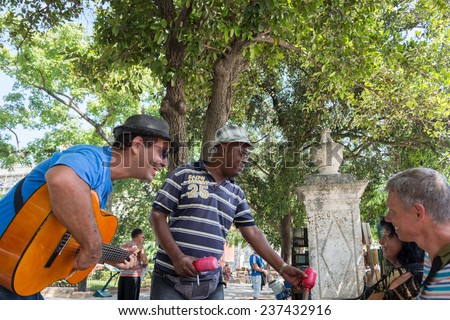 HAVANA,CUBA-JULY 17,2014: Ambulant street musicians chase tourists in Old Havana and they please them with music in exchange for tips in dollars