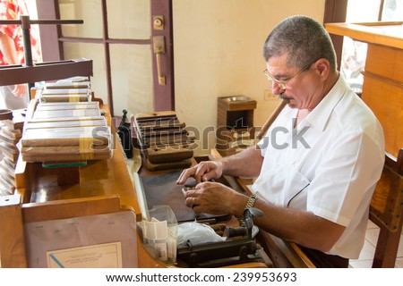 TRINIDAD,CUBA-JULY 22,2014: Cigar roller in the Casa del Habano or House of the Cuban cigar. Trinidad was the eighth village founded by Spanish colonizers and today is a UNESCO world heritage site.