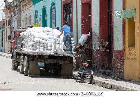 SANTA CLARA,CUBA-JULY 4,2014: Unloading a truck of flour in a Cuban dining room for people in need or social cases. One of the major achievements of the Cuban Revolution is serve those in need.