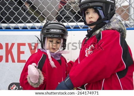 TORONTO,CANADA-JANUARY 3,2015: Community children enjoying the official opening of the Regent Park ice rink where there were Maple Leaf alumni and Police officers to teach them skate