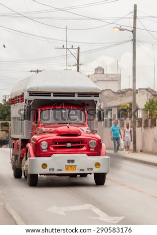 SANTA CLARA,CUBA-JULY 14,2014: Old vintage American truck in Cuba: Red truck transporting cargo on a city street in day.Changes in the economic model are happening by the day.