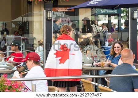 Canada Day celebrations in Toronto: Restaurant server or waitress with Canadian Flag on the back in Irish Pub Patio in the Harborfront
