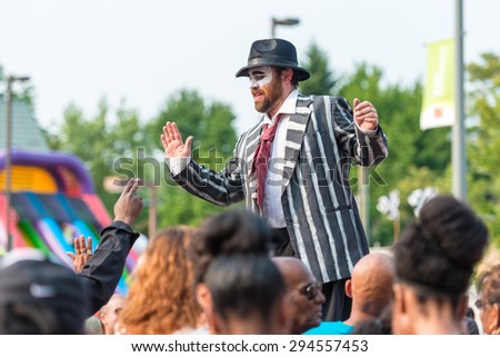 TORONTO,CANADA-JULY 5,2015: Man in stilts among the crowd in Salsa on St. Clair Ave West is the largest Hispanic festival in Canada gathering thousands every year.
