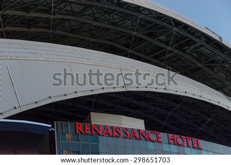 TORONTO,CANADA-JUNE 22,2015: Renaissance Hotel exterior with moving roof of Rogers Centre.  A steel arch swoops over the glass windows and the red neon sign bearing the name of the hotel.